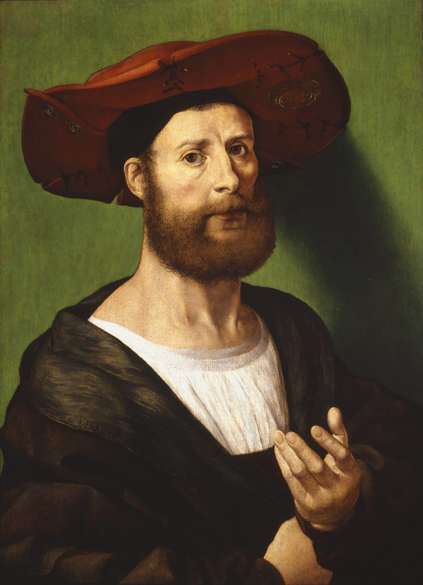 a portrait of a man in a red hat and a brown and white garment gesturing to the viewer with his left hand