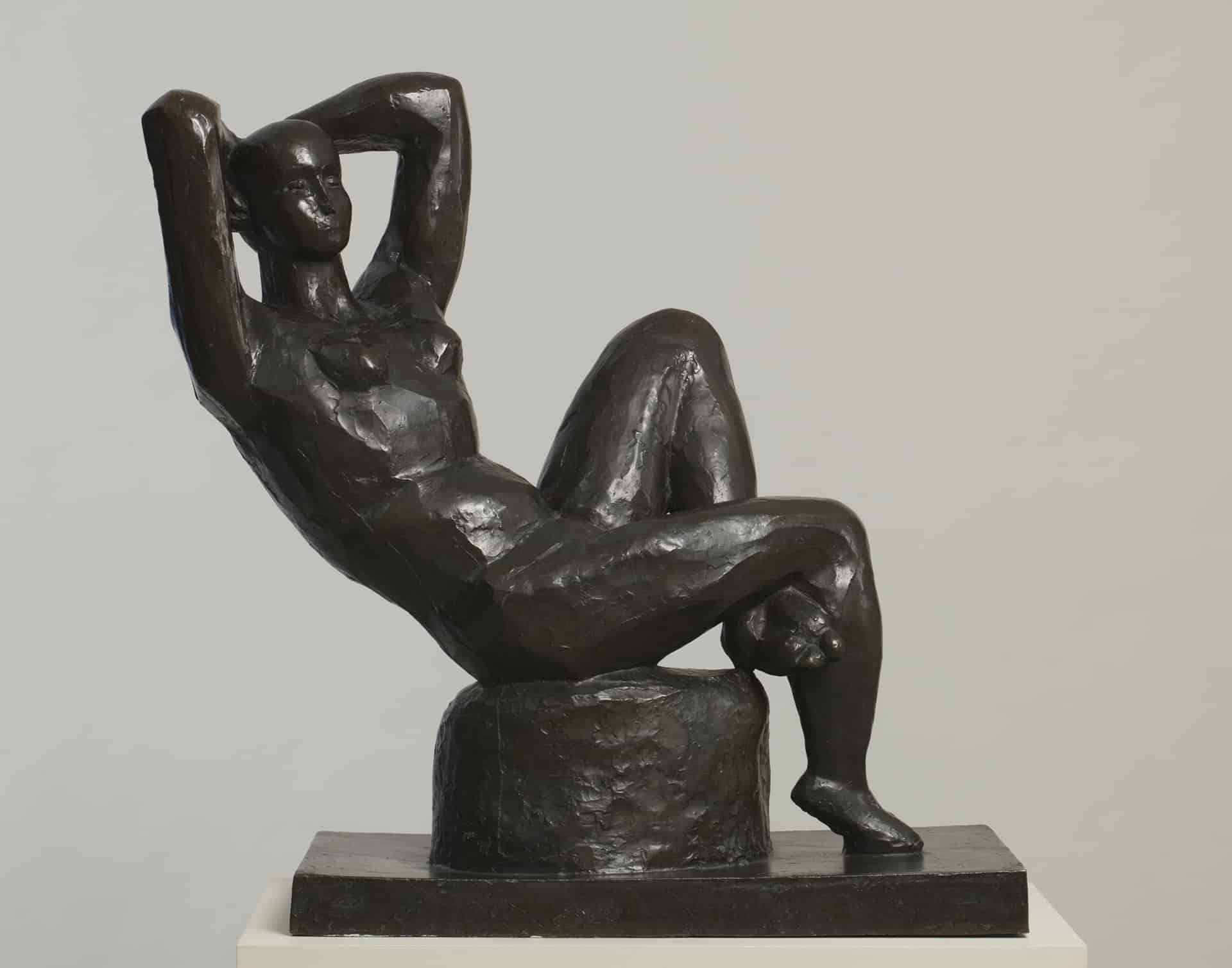 a bronze woman reclining with her arms above her head