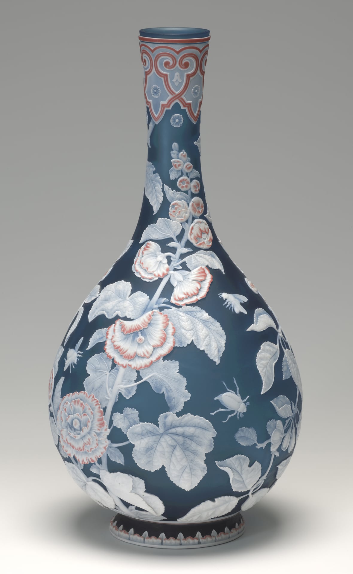 a blue glass vase with light blue and pink cameo flowers