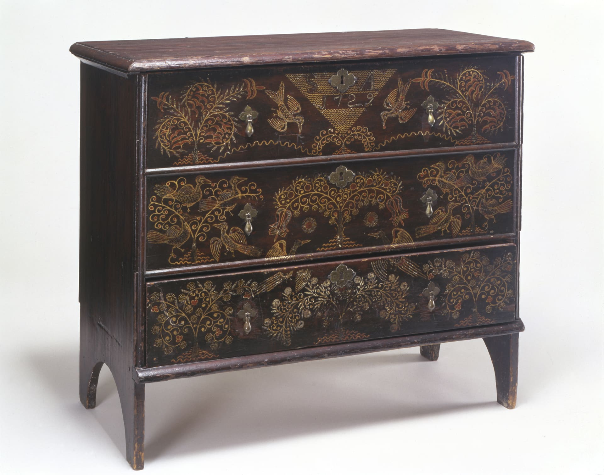 a chest of three drawers with a decorative pattern on the face