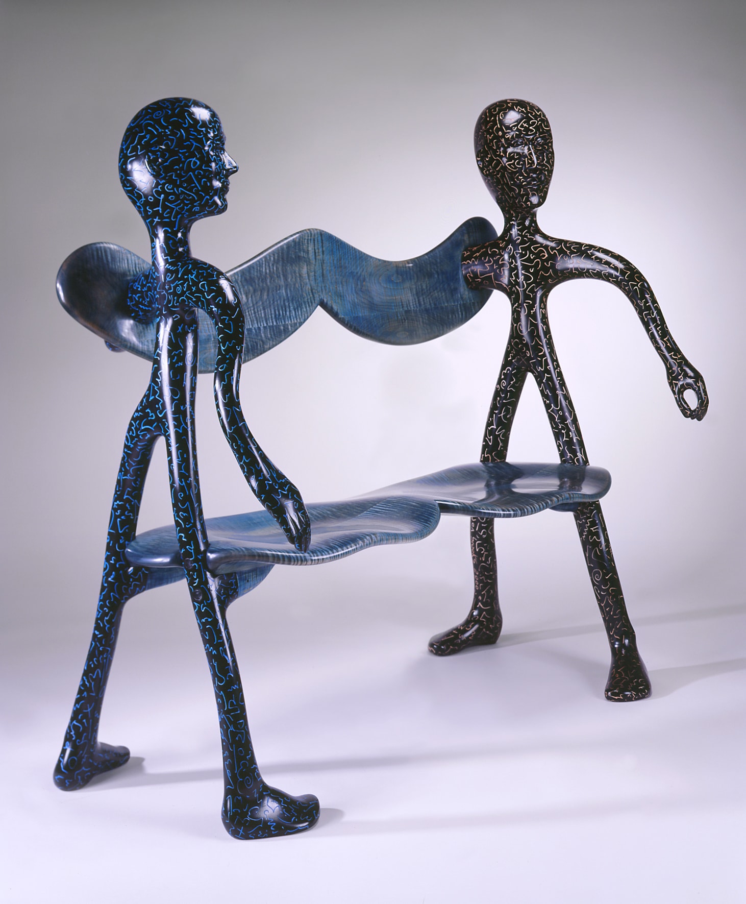 a blue bench in the shape of two standing figures on either end