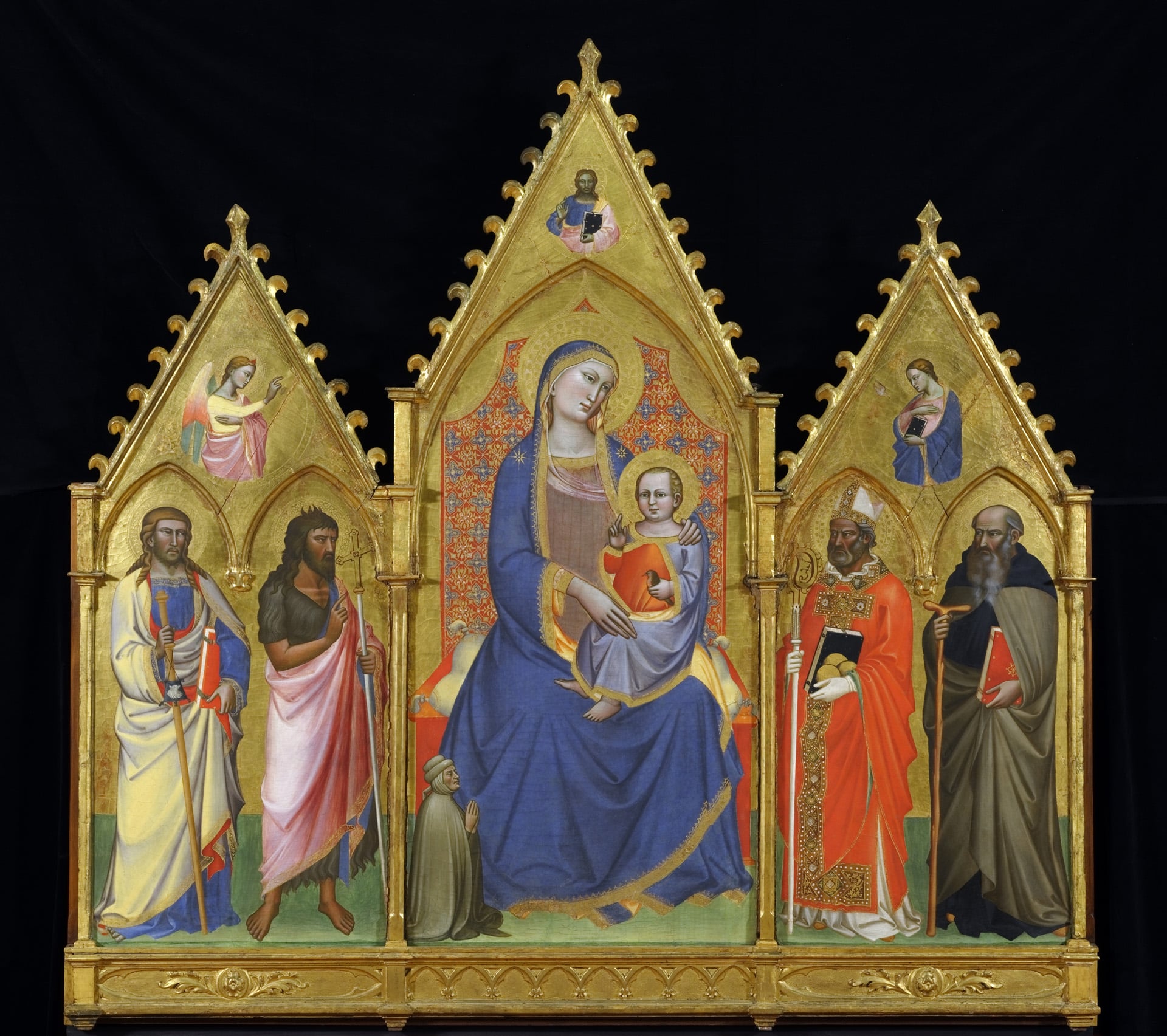 a painted three-panel altarpiece with the virgin mary in blue and the christ child on her lap in the center, and two saints on each side panel
