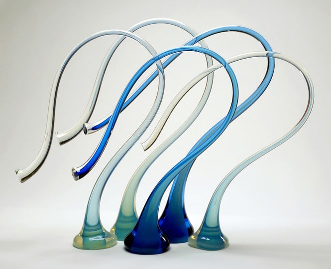 five blue glass figures in the shape of the top of a curved staff