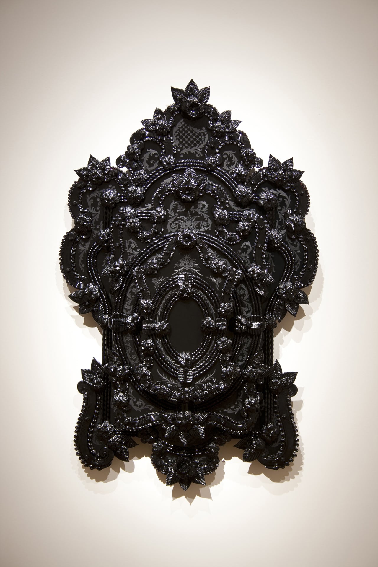 an ornate decorative all black glass mirror