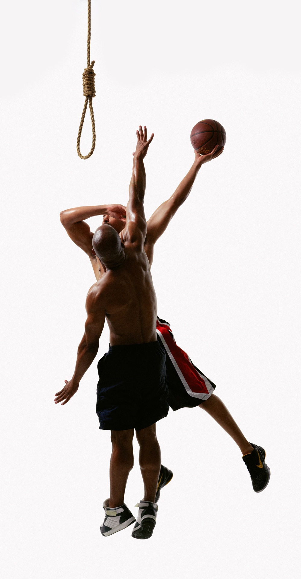a photograph of two Black men playing basketball, a noose hangs over their heads