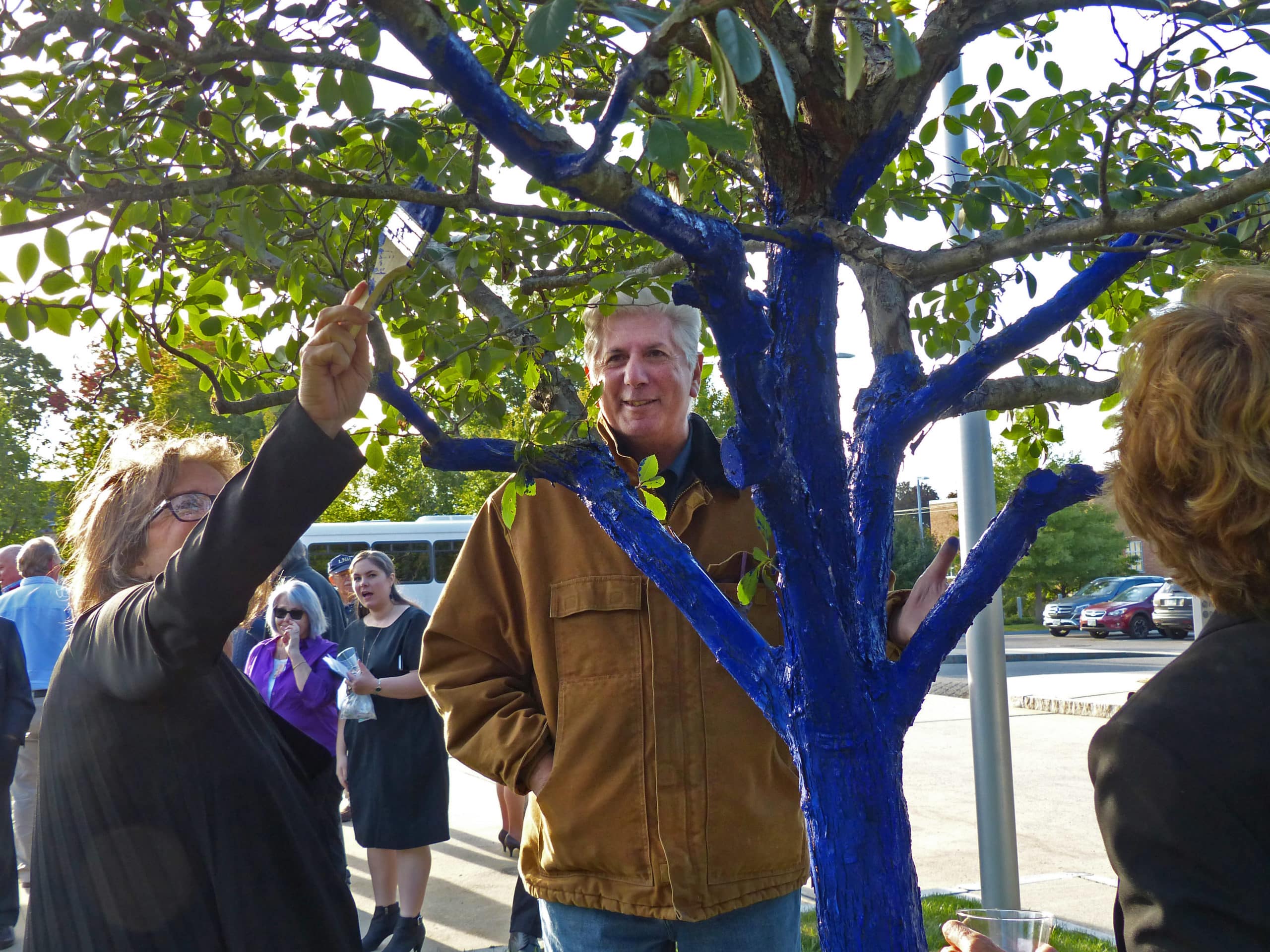 a tall man with white hair as seen through a blue-colored tree