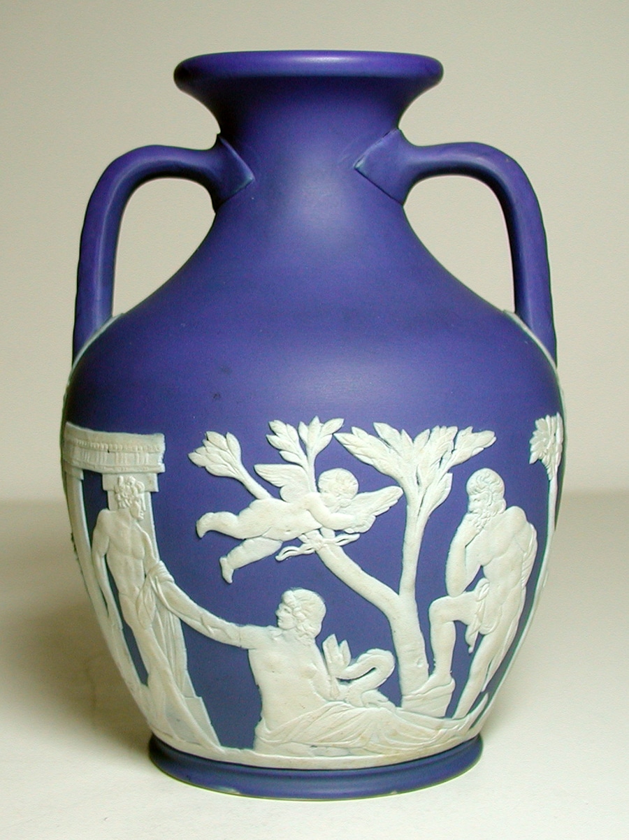 a blue vase with white cameos of an ancient greek scene decorating the base