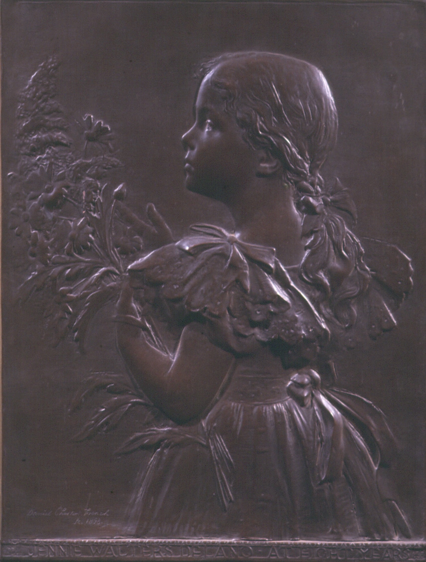 a low relief bronze of a girl holding flowers, her back is turned toward the viewer, her face is in profile.