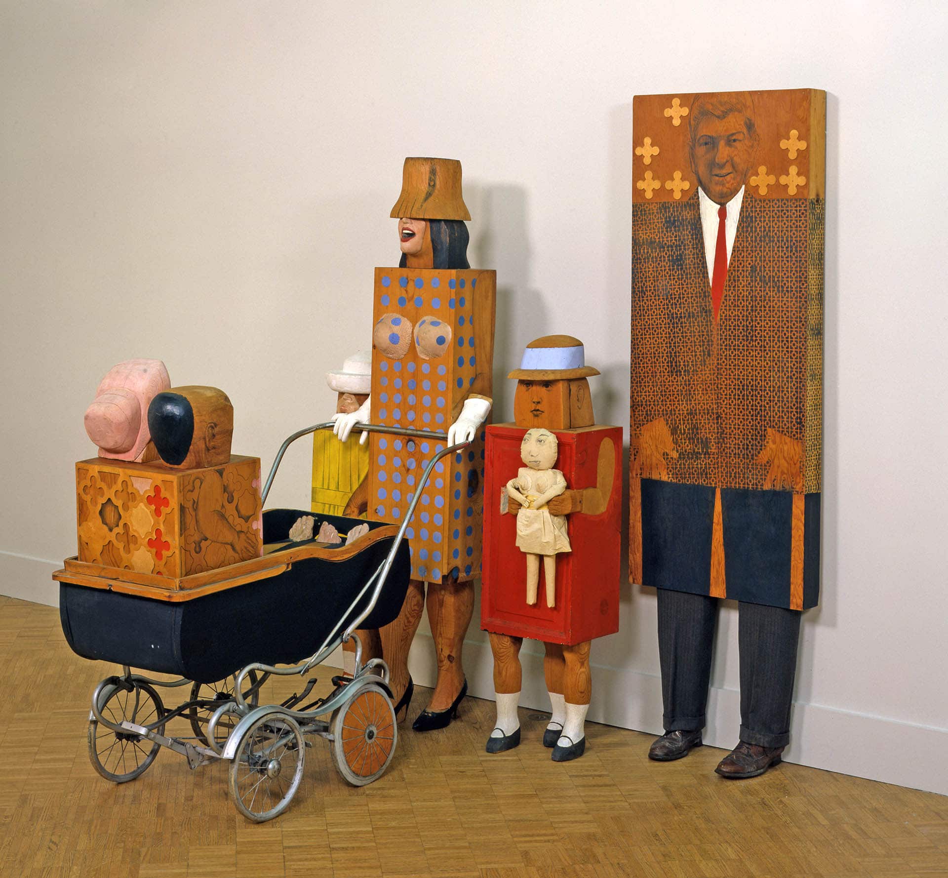a sculpture of 5 people made of boxes, a mother, father, two daughters and baby in a carriage