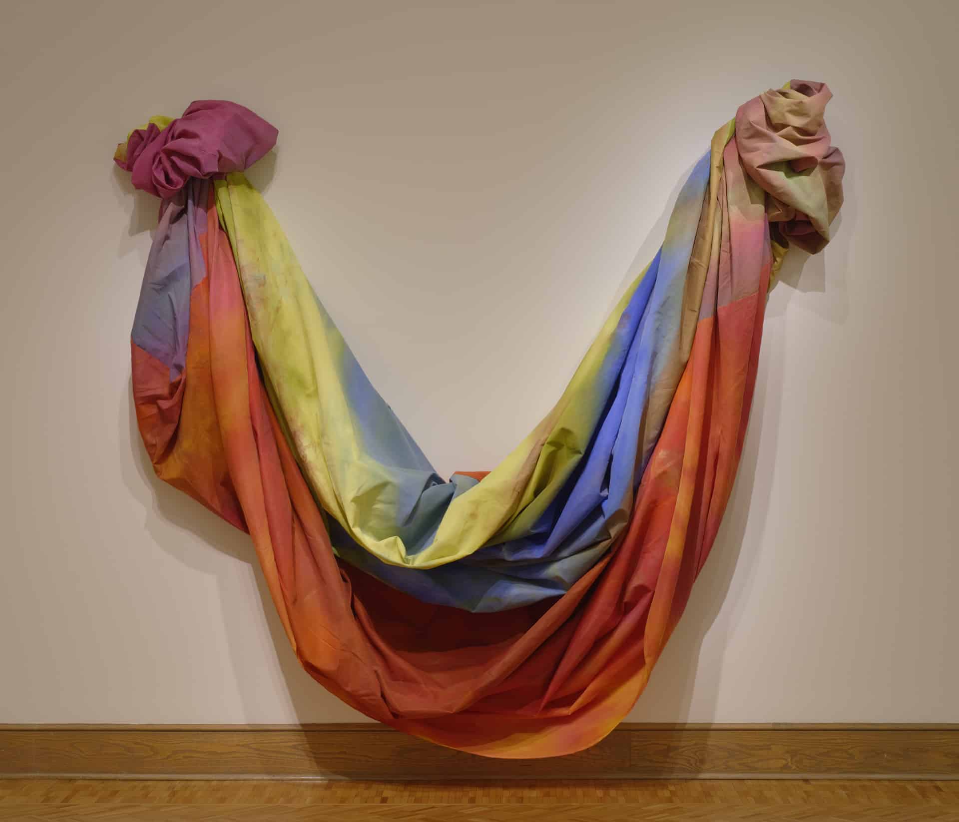a large, colorful swag of fabric hung from the wall in a u-shape