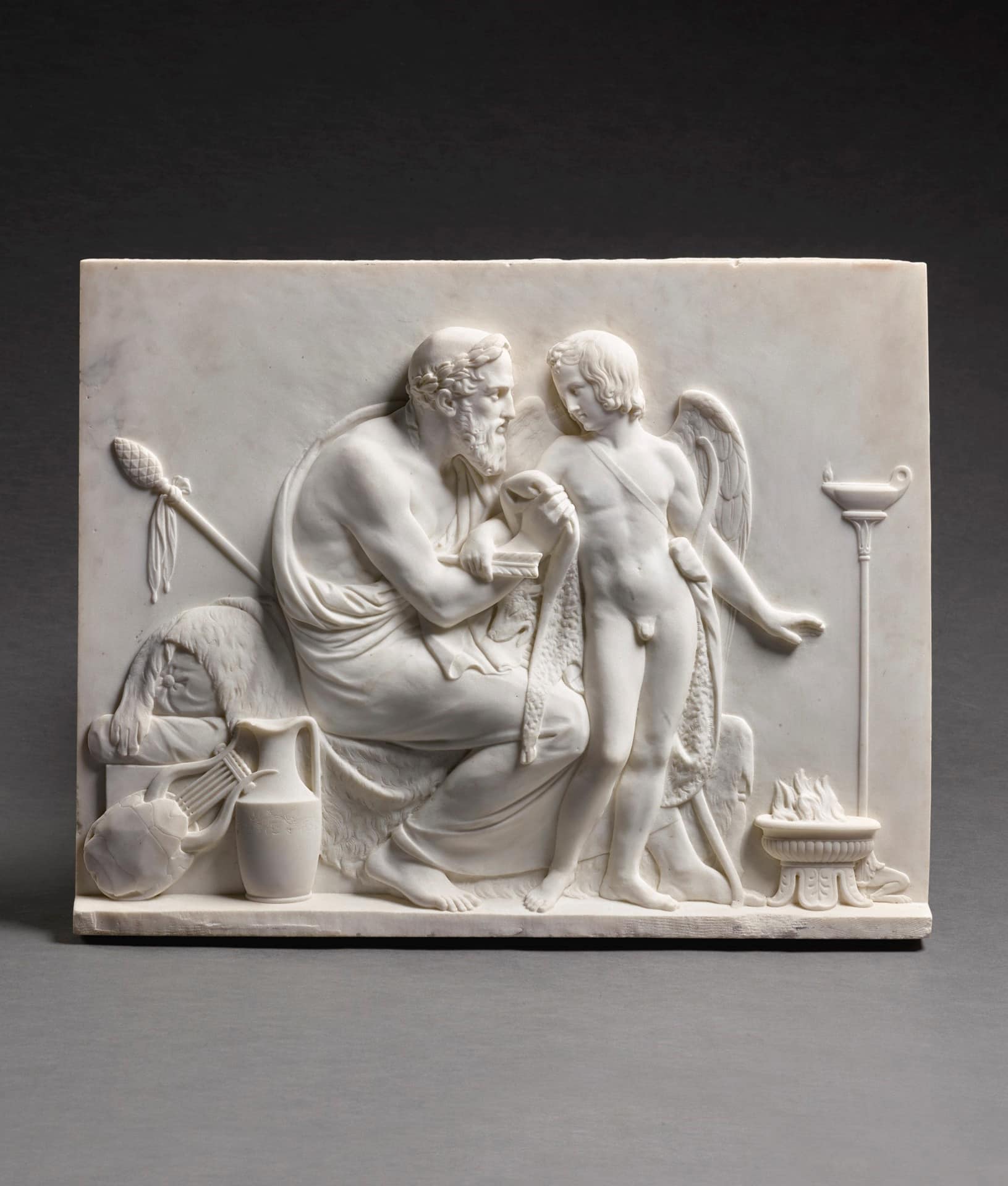 a marble relief of an old man and a cupid