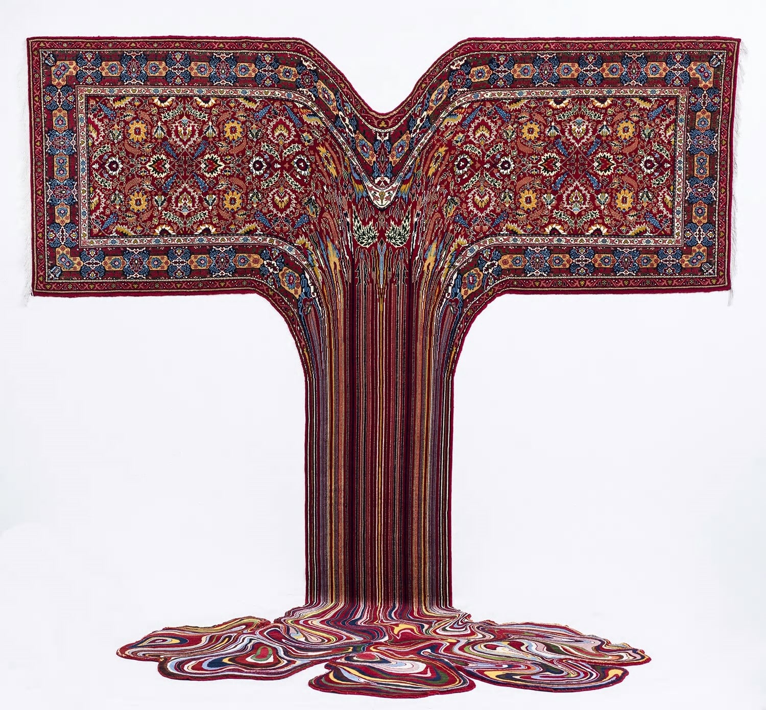 a wall-mounted oriental carpet that pools in threads on the floor